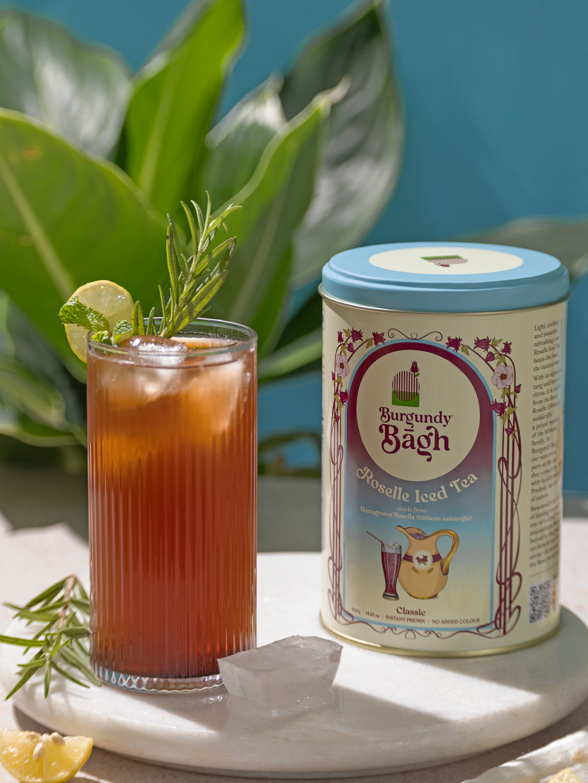 Burgundy Bagh Roselle Iced Tea served over ice in a tall glass with lime