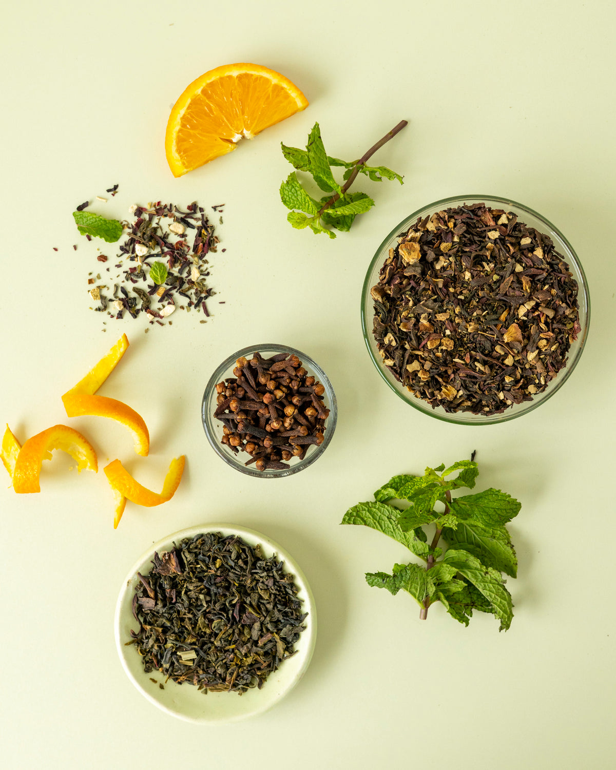 Fresh mint, citrus peel and roselle leaves in small bowls