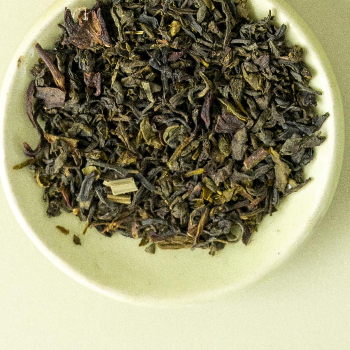 Whole leaf green tea in a white bowl