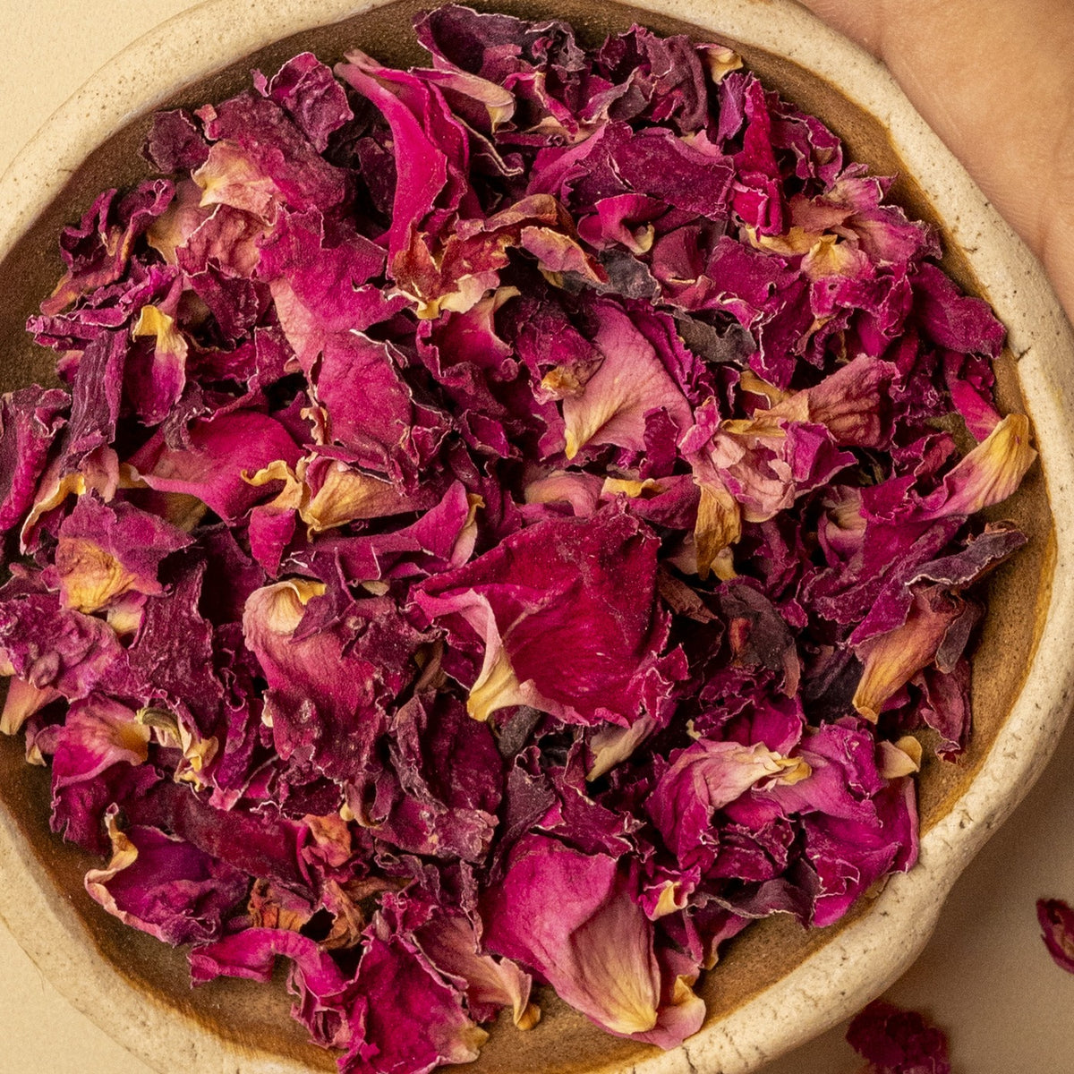 Dried rose petals in a wooden bowl